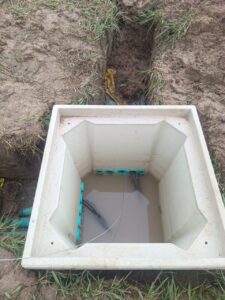 Caja de inspección pequeña REFORPLAS instalada en terreno con conductor de puesta a tierra
