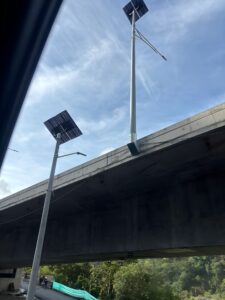 Postes en fibra de vidrio con luminaria solar junto a puente