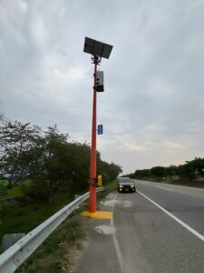 Poste en fibra de vidrio con panel solar al borde de la vía
